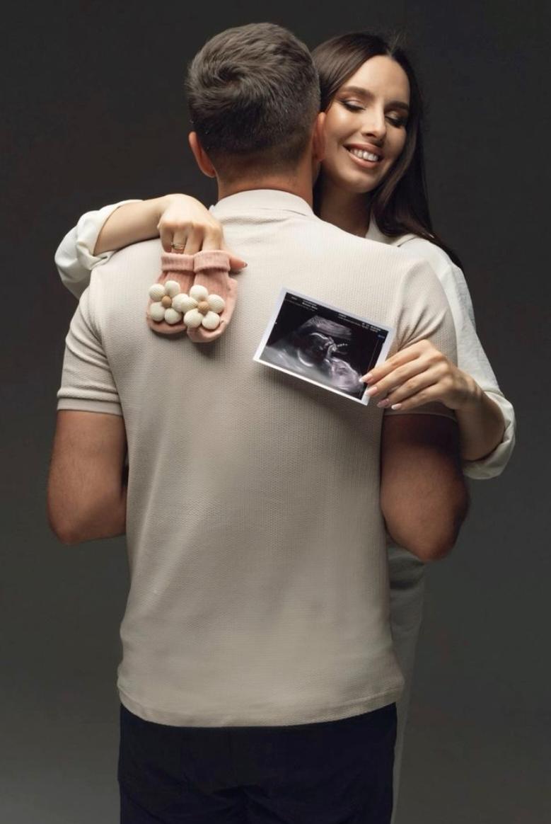 Couple holding baby shoes